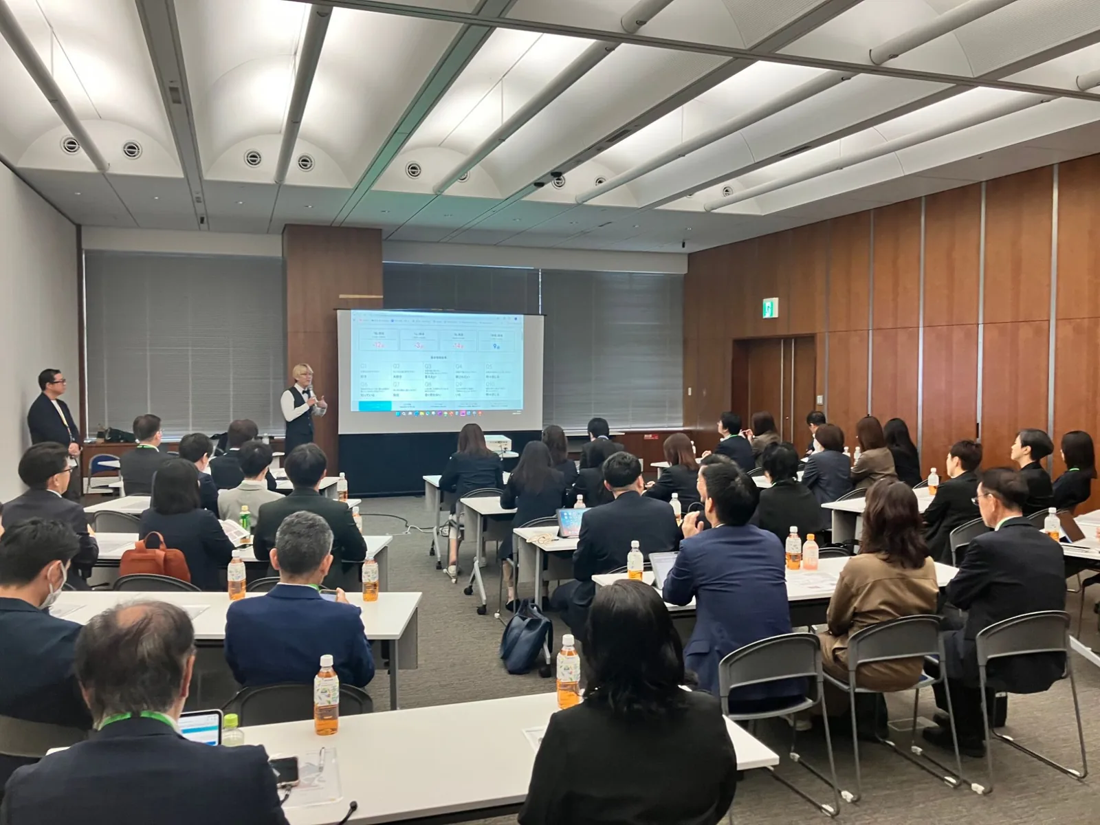 会議室で、お風呂のソムリエ 松永武がスライドを映しながら、ショールームのスタッフの方々に話している研修の様子